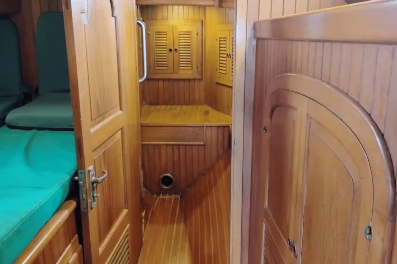 Slide: The Image of Interior of 1985 Hans Christian 38 sailboat with wooden paneling and green cushions. - 19