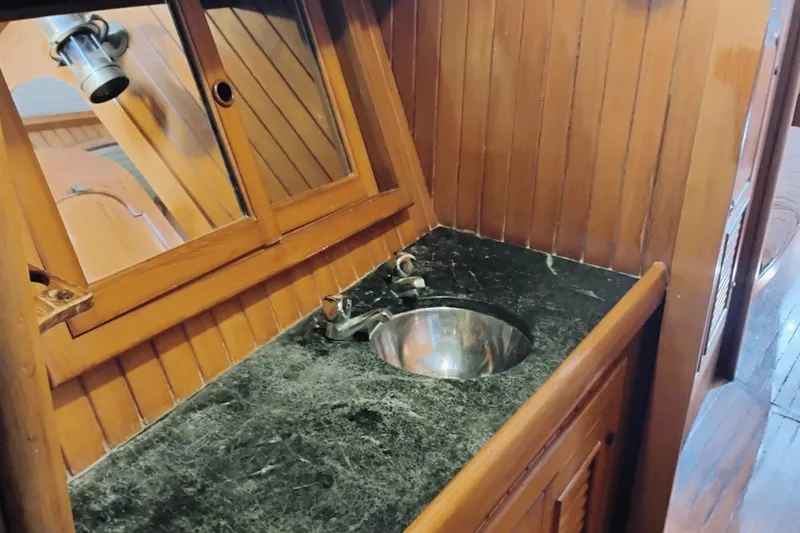 Slide: The Image of Wood-paneled bathroom with marble countertop and sink on 1985 Hans Christian 38 yacht. - 20
