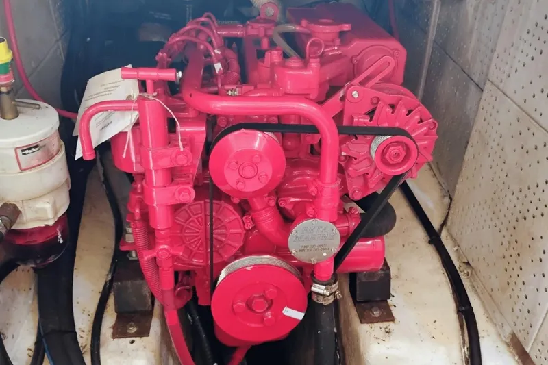 Slide: The Image of Red engine inside a 1985 Hans Christian 38 sailboat, showcasing mechanical components. - 22