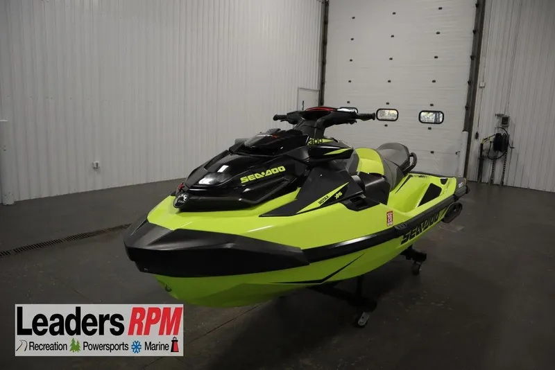 The Image of 2018 Sea-Doo RXT-X 300 jet ski in a showroom, vibrant yellow and black design. - 1