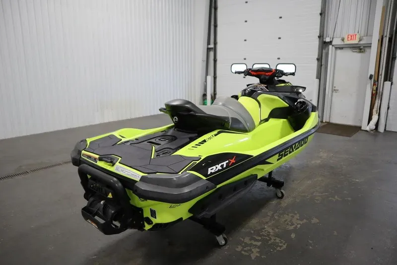 Slide: The Image of 2018 Sea-Doo RXT-X 300 jet ski in vibrant green, parked indoors. - 5