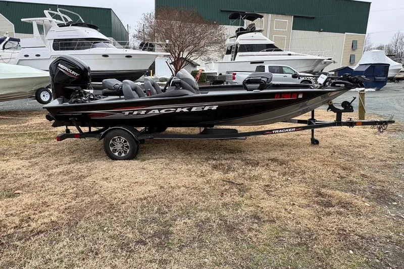 The Image of 2023 Tracker Pro Team 175 TXW boat on trailer, parked outdoors near other boats. - 0