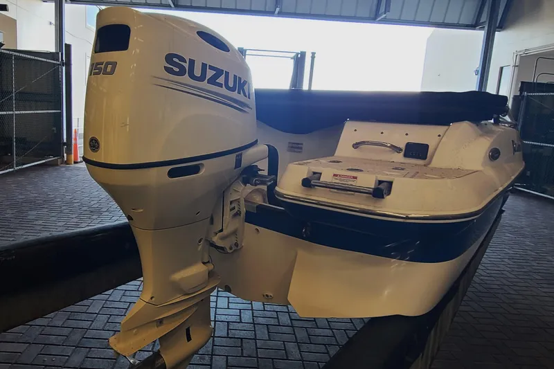 Slide: The Image of 2021 Campion Chase 20 boat with Suzuki 150 outboard motor in a garage. - 13
