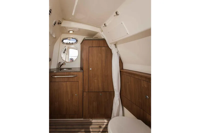 Slide: The Image of Manufacturer Provided Image: 2018 Boston Whaler 350 Outrage cabin interior with wooden cabinetry and compact bathroom. - 10