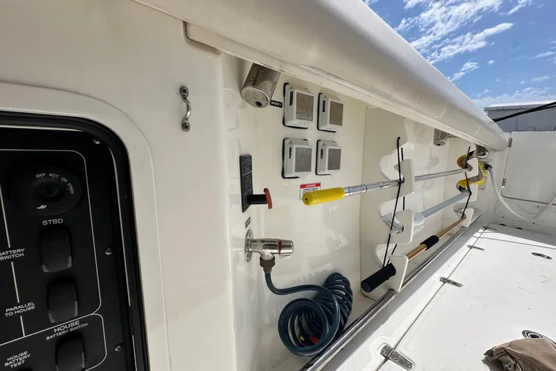 Slide: The Image of 2018 Boston Whaler 350 Outrage deck with fishing rod holders and control panel. - 13