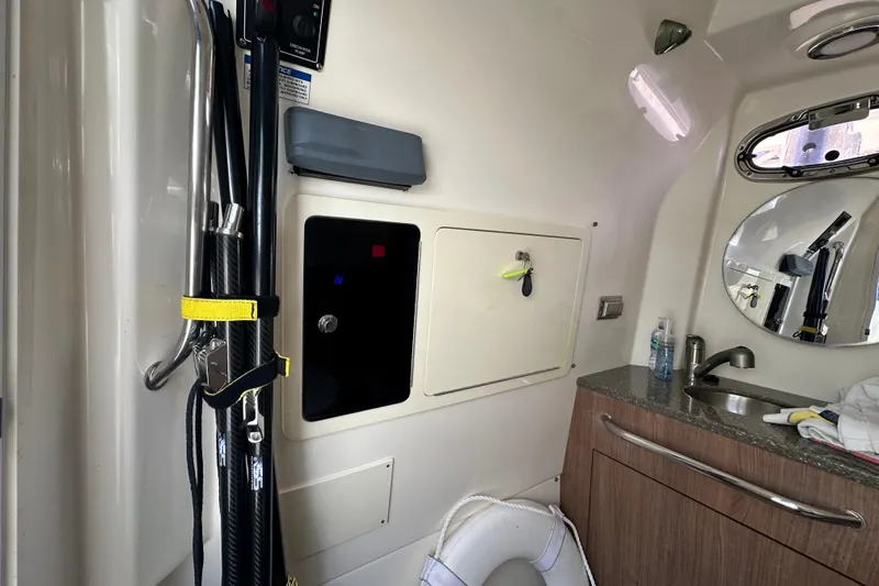 Slide: The Image of Interior of 2018 Boston Whaler 350 Outrage, featuring sink, mirror, and storage compartments. - 16