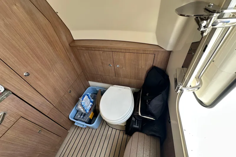 Slide: The Image of 2018 Boston Whaler 350 Outrage cabin interior with toilet and storage area. - 17