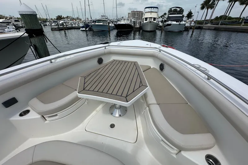 Slide: The Image of 2018 Boston Whaler 350 Outrage boat interior with seating and table, docked at marina. - 19