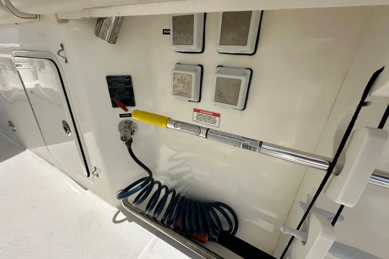 Slide: The Image of 2018 Boston Whaler 350 Outrage boat interior with control panel and coiled hose. - 26