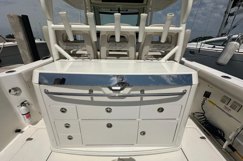 Slide: The Image of 2018 Boston Whaler 350 Outrage boat cockpit with storage drawers and rod holders. - 27