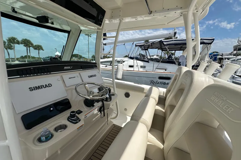 Slide: The Image of 2018 Boston Whaler 350 Outrage helm with Simrad electronics, docked near sailboats. - 32