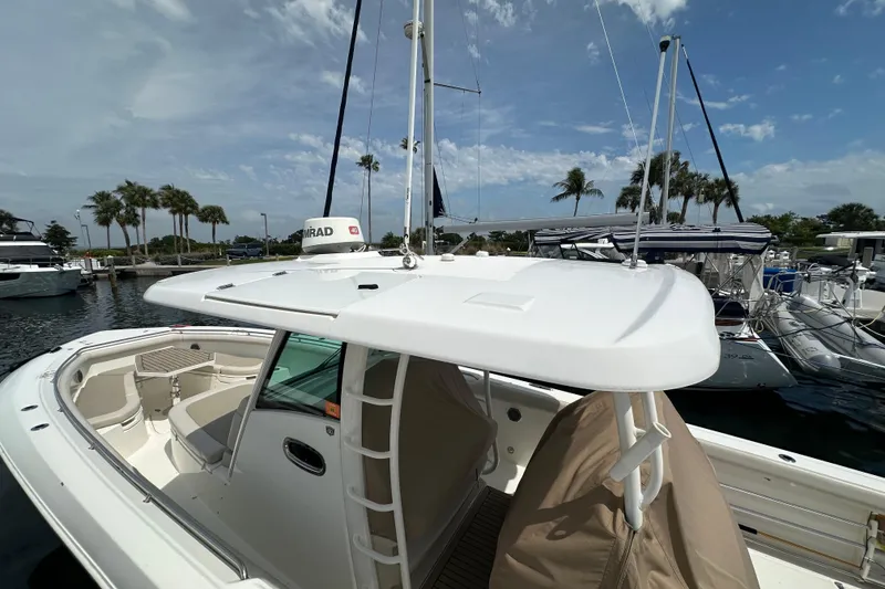 Slide: The Image of 2018 Boston Whaler 350 Outrage boat docked, featuring spacious seating and radar equipment. - 37