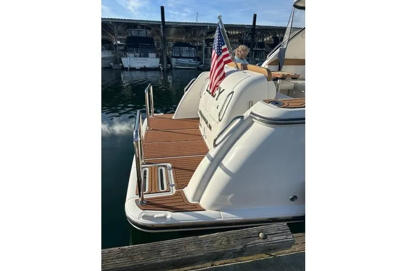 Slide: The Image of 2008 Tiara Yachts 3900 Sovran docked, featuring a wooden deck and American flag. - 10