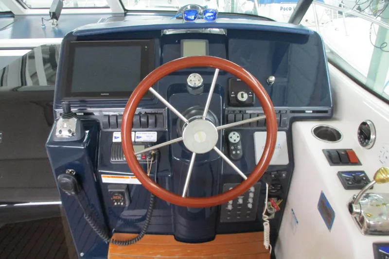 Slide: The Image of 2008 Tiara Yachts 3900 Sovran helm with wooden steering wheel and navigation controls. - 28