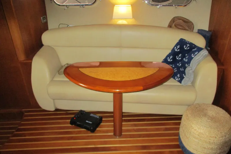 Slide: The Image of Interior of 2008 Tiara Yachts 3900 Sovran with beige sofa, wooden table, and nautical decor. - 33