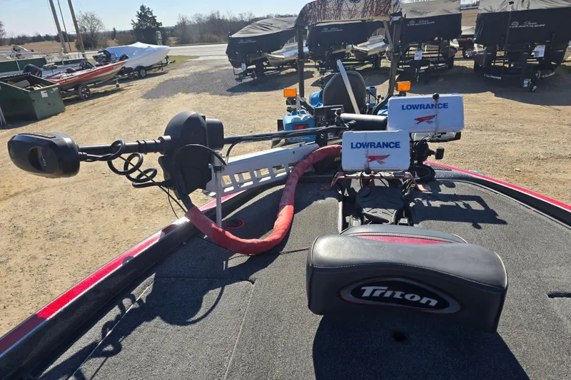 Slide: The Image of 2009 Triton 20X3 Pro DC boat with Lowrance electronics and trolling motor, parked outdoors. - 10