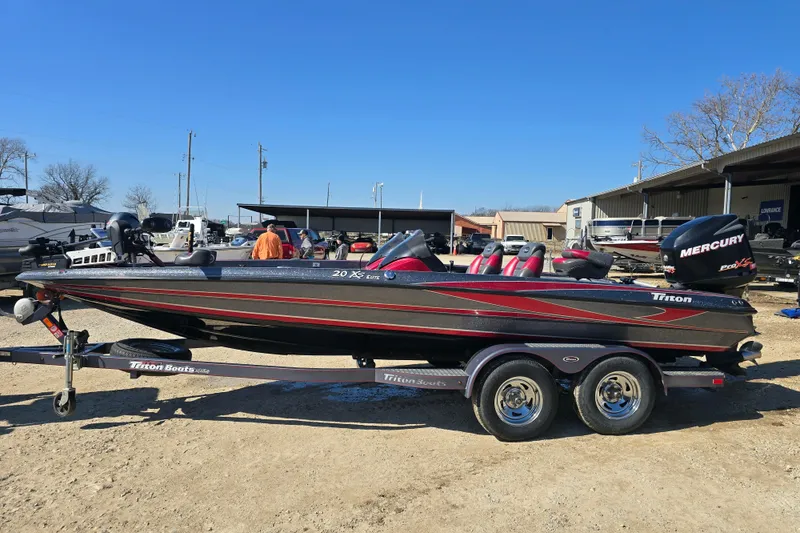 Slide: The Image of 2009 Triton 20X3 Pro DC boat on trailer, featuring Mercury engine, parked outdoors. - 3