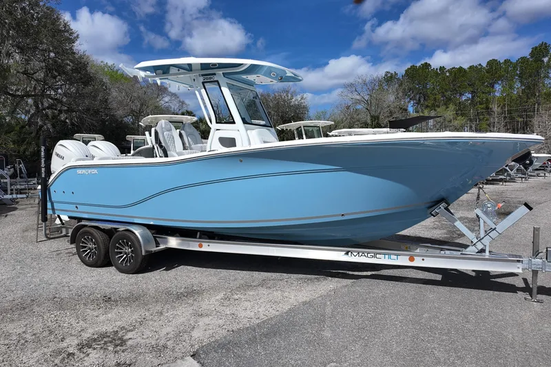 The Image of 2026 Sea Fox 268 Commander boat on trailer, blue hull, parked outdoors. - 0