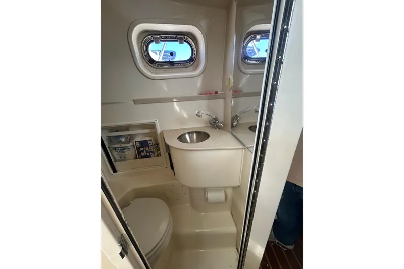 Slide: The Image of Compact bathroom in 2006 Pursuit 3070 Offshore boat with sink and toilet. - 19