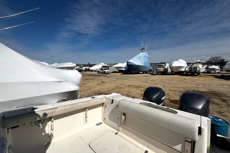 Slide: The Image of Outdoor storage of boats, including a 2006 Pursuit 3070 Offshore, under clear blue skies. - 23
