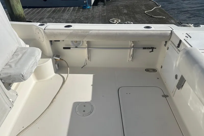 Slide: The Image of 2006 Pursuit 3070 Offshore boat interior with seating and storage, docked by the water. - 6