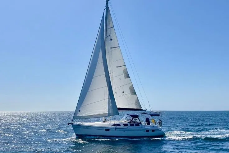 The Image of 2004 Hunter 386 sailboat cruising on open sea under clear blue sky. - 0