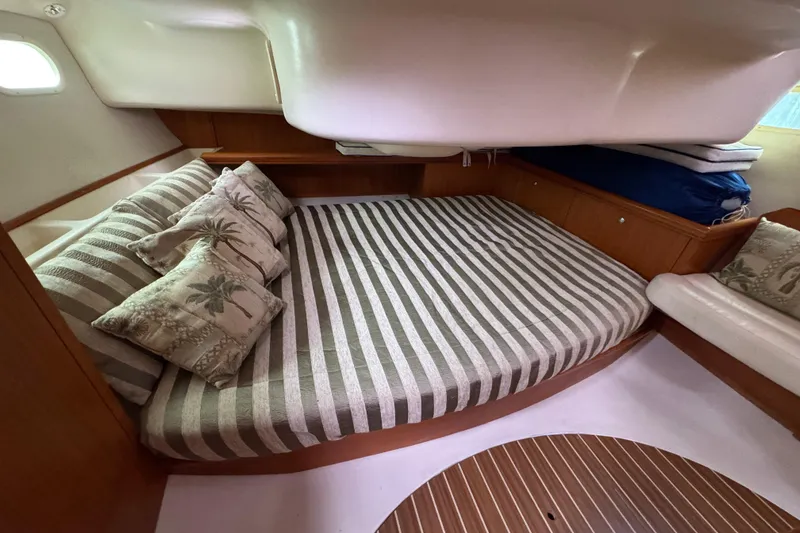 Slide: The Image of 2004 Hunter 386 yacht interior with striped bedding and decorative pillows. - 11