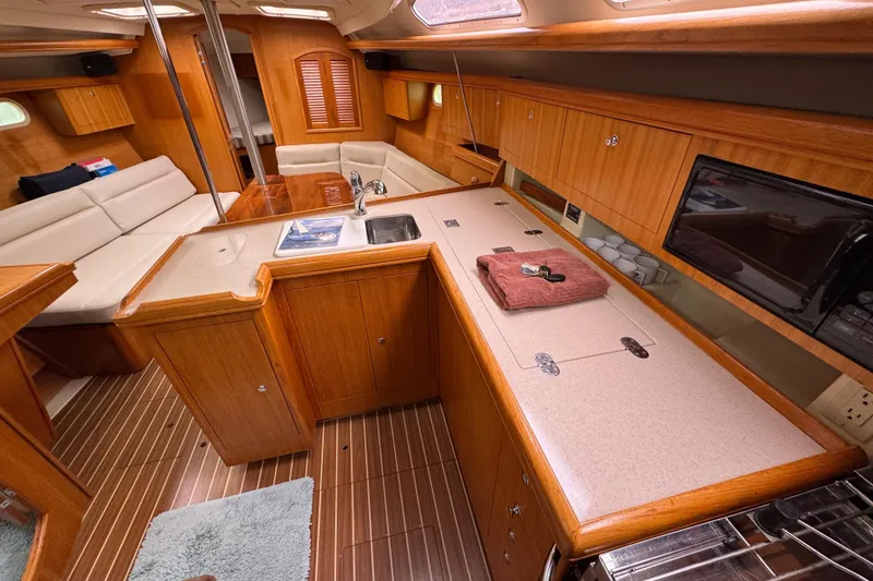 Slide: The Image of Interior of 2004 Hunter 386 sailboat with wood cabinetry and modern amenities. - 12