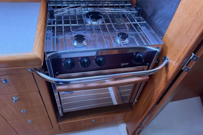 Slide: The Image of Stove and oven in 2004 Hunter 386 yacht kitchen, featuring wooden cabinetry. - 14