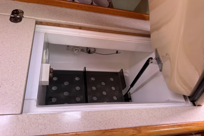 Slide: The Image of Open storage compartment in 2004 Hunter 386 boat with hydraulic lift and perforated shelf. - 15