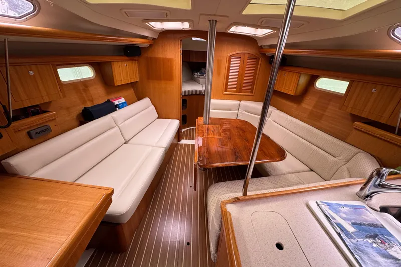 Slide: The Image of Luxurious interior of a 2004 Hunter 386 sailboat with wood finishes and comfortable seating. - 6