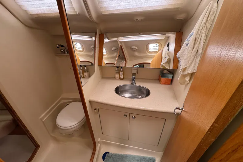 Slide: The Image of 2004 Hunter 386 yacht bathroom with sink, mirror, and toilet. - 9