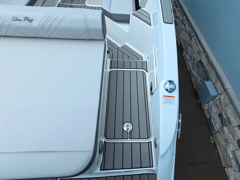 Slide: The Image of The image shows the deck of a Sea Ray SDX 270 Outboard boat with gray and white details. - 10