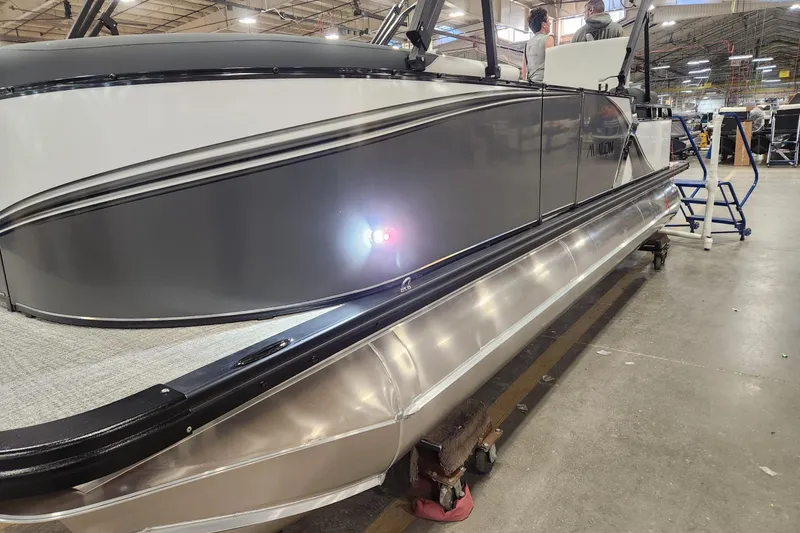 Slide: The Image of 2026 Tahoe Pontoon LTZ Quad Lounger Shift 23 in a factory setting. - 2