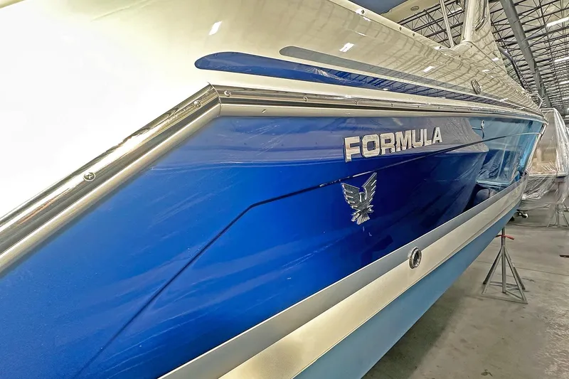 Slide: The Image of 2005 Formula 330 Sun Sport boat with blue and white exterior in a storage facility. - 3