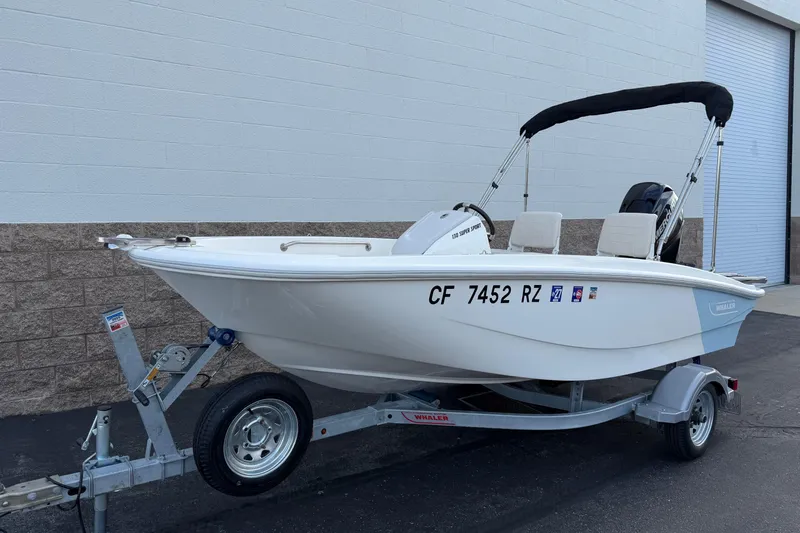 Slide: The Image of 2020 Boston Whaler 130 Super Sport boat on trailer, parked outdoors. - 10