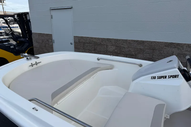 Slide: The Image of 2020 Boston Whaler 130 Super Sport boat interior, featuring seating and steering console. - 13