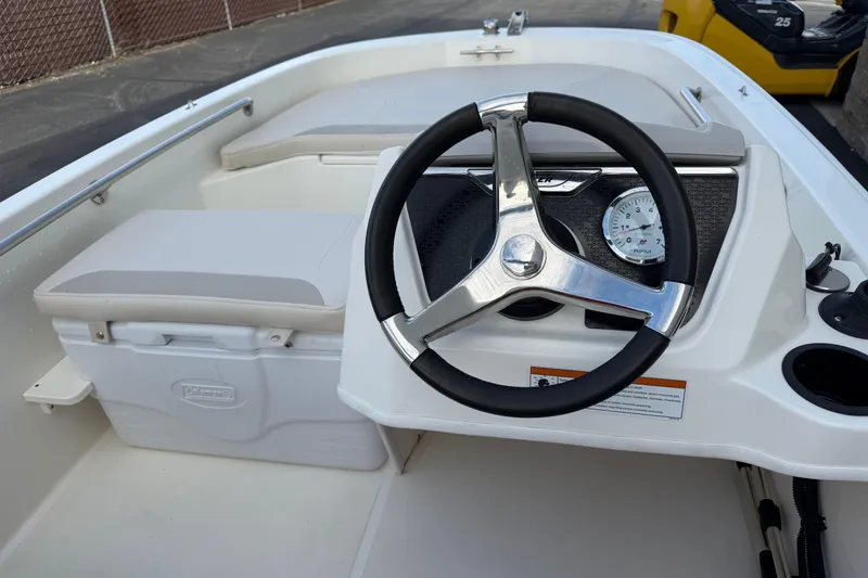Slide: The Image of 2020 Boston Whaler 130 Super Sport boat interior with steering wheel and seating. - 15