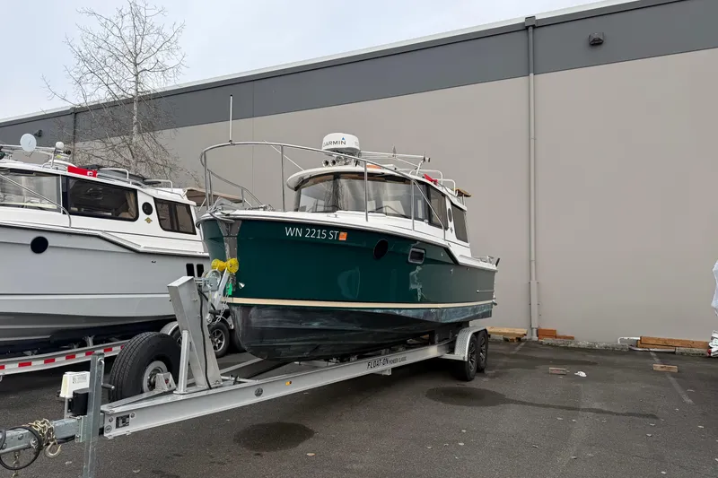 The Image of 2019 Ranger Tugs R-23 boat on trailer, parked outdoors near a building. - 1