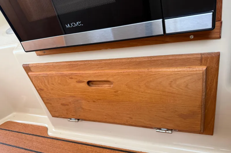 Slide: The Image of Wooden storage compartment and microwave in 2019 Ranger Tugs R-23 boat interior. - 12
