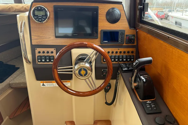 Slide: The Image of 2019 Ranger Tugs R-23 helm with wooden steering wheel and modern controls. - 5