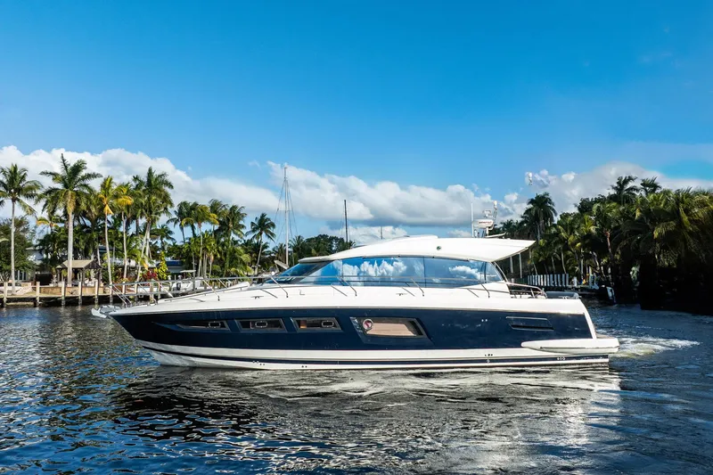Slide: The Image of 2013 Prestige 500S yacht cruising on a sunny day with palm trees in the background. - 5