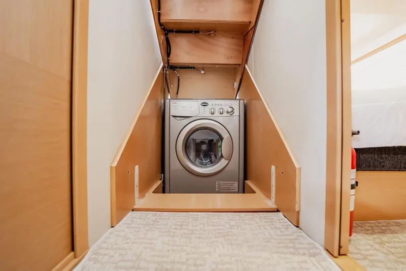 Slide: The Image of Laundry area inside 2013 Prestige 500S yacht, featuring a compact washing machine. - 50