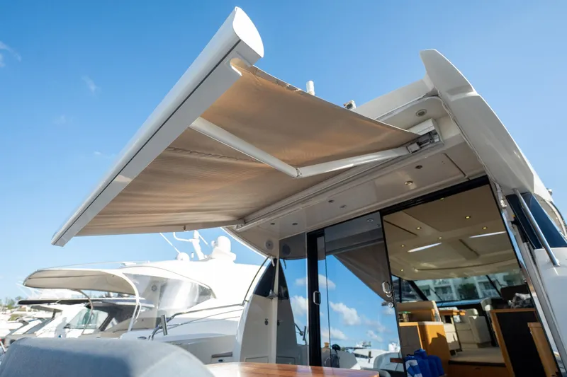 Slide: The Image of 2013 Prestige 500S yacht with extended sunshade, docked under clear blue sky. - 72