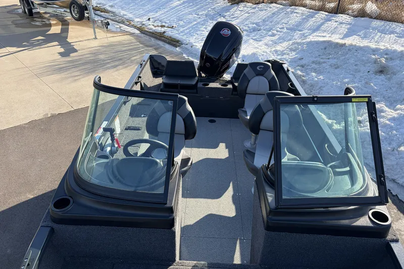 Slide: The Image of 2026 Crestliner 1850 Kodiak WT boat with dual consoles and outboard motor, parked on snowy pavement. - 18