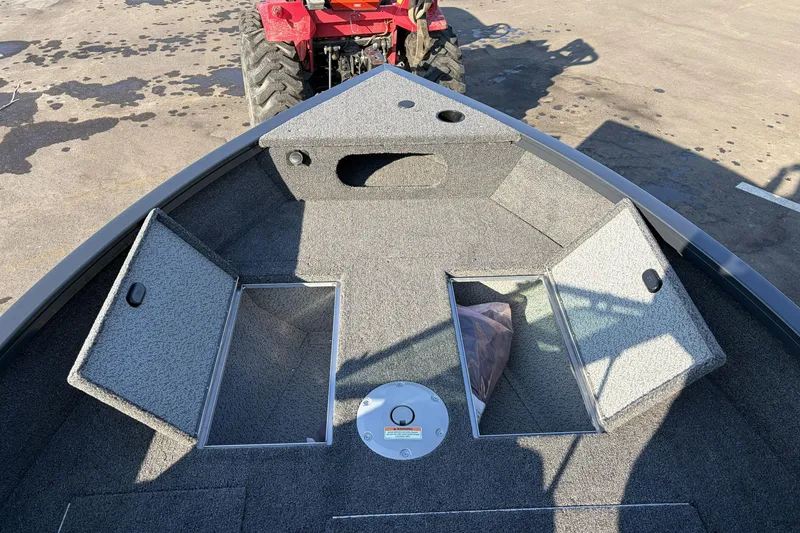 Slide: The Image of 2026 Crestliner 1850 Kodiak WT boat interior with storage compartments, parked on concrete. - 20