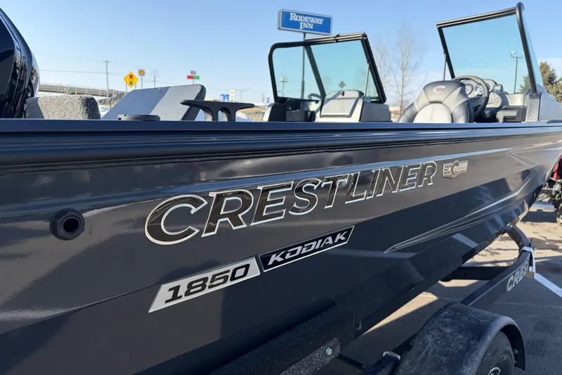 Slide: The Image of 2026 Crestliner 1850 Kodiak WT boat, sleek design, parked outdoors. - 26
