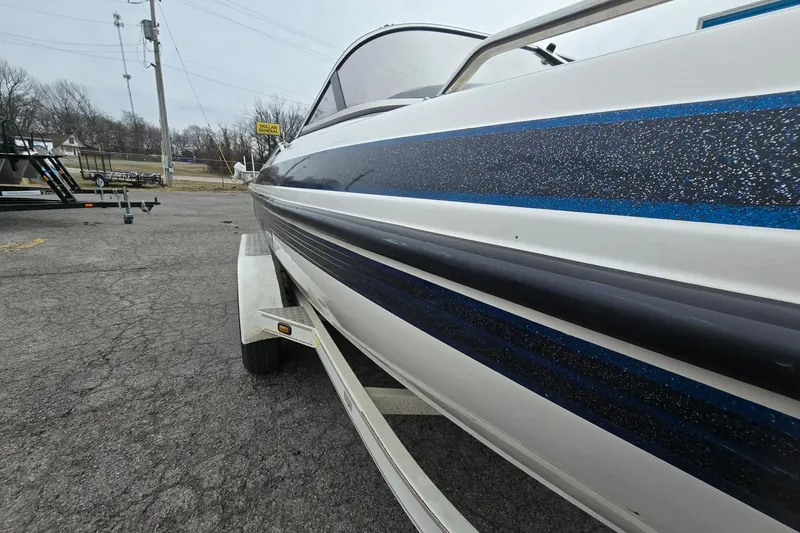 Slide: The Image of 2001 Skeeter SL 190 boat on trailer, side view with blue and black stripes. - 18