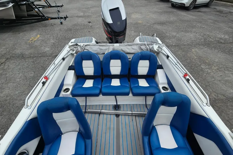 Slide: The Image of 2001 Skeeter SL 190 boat interior with blue and white seating, parked on pavement. - 6