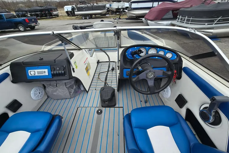 Slide: The Image of 2001 Skeeter SL 190 boat interior with blue and white seating, steering wheel, and dashboard controls. - 9